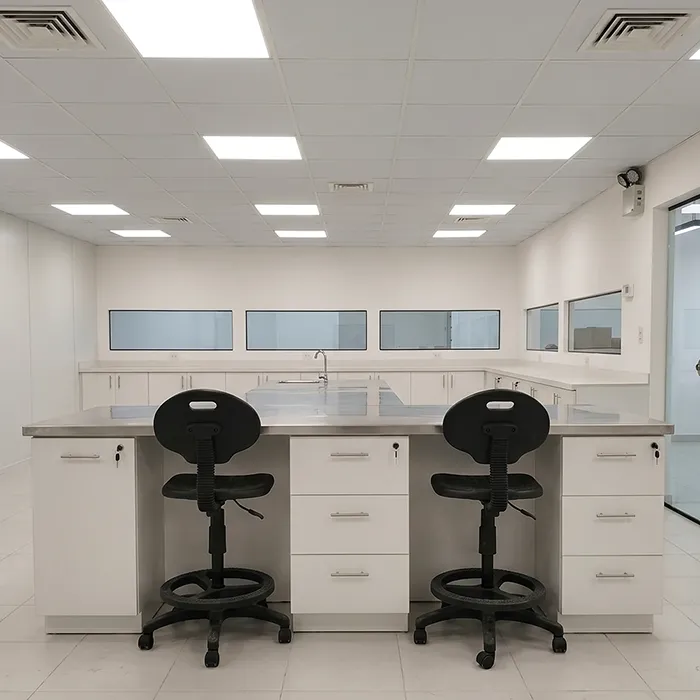 Mesa central tipo isla para laboratorio con superficie de acero inoxidable 304 y cajoneras fijas.